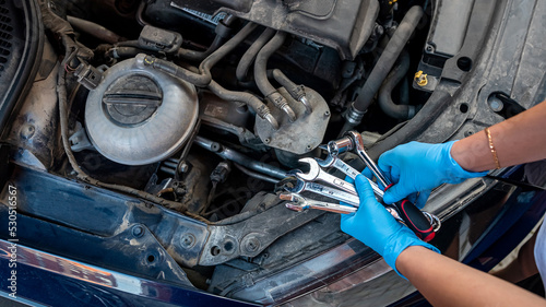 car mechanic works in a garage to repair a car.