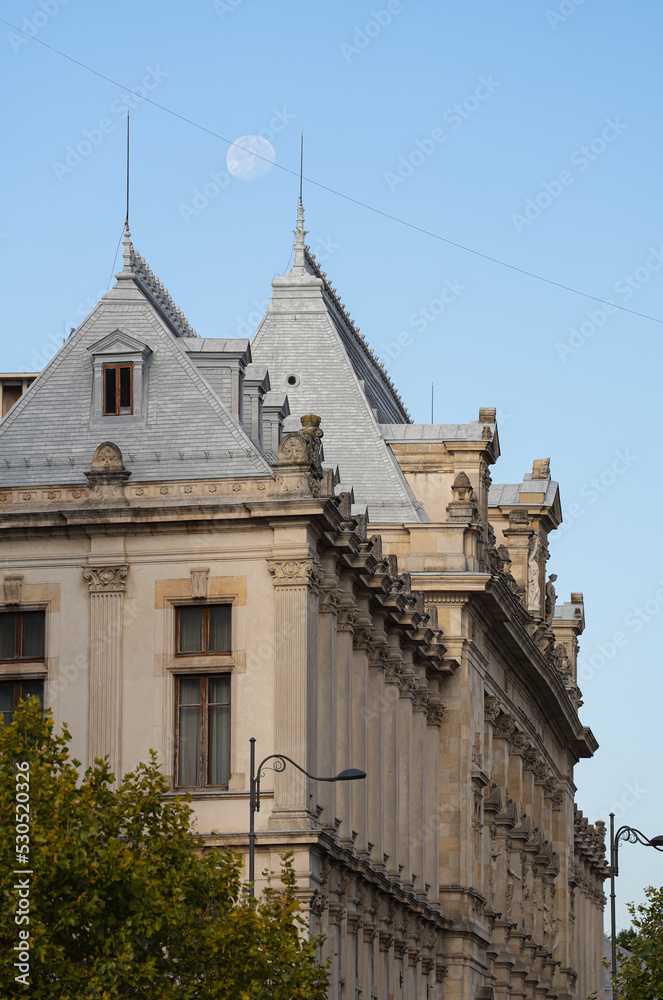 Moon rising up above the Palace of Justice landmark building from Bucharest. Travel to Romania.
