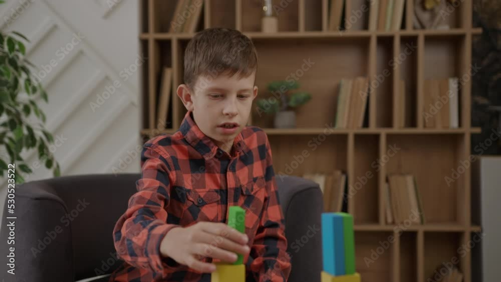 Kid with autism making assignment of therapist with colour wooden