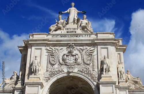 Monument and statues at Lisbon Main Square; Lisbon, Portugal, Europe. This historical Triumphal Arch is the gate that connects Lisbon to the Tagus river. Commerce Square view with Rua Agusta. photo