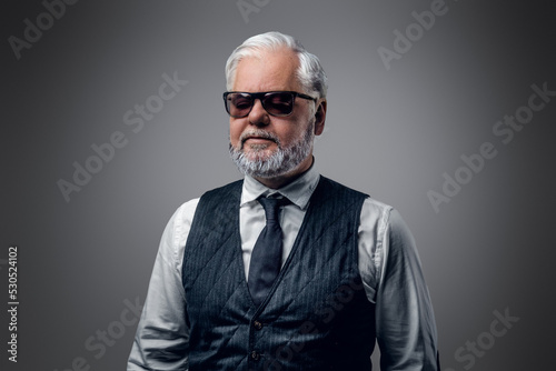 Fototapeta Portrait of cool old man with sunglasses dressed in waistcoat and white shirt