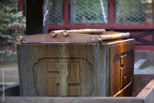 Japanese traditional ablution pavilion adorned with a carved Buddhist swastika cross. photo
