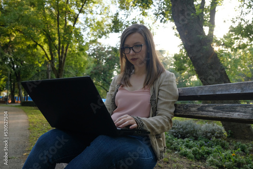 Young woman working on a laptop in the park