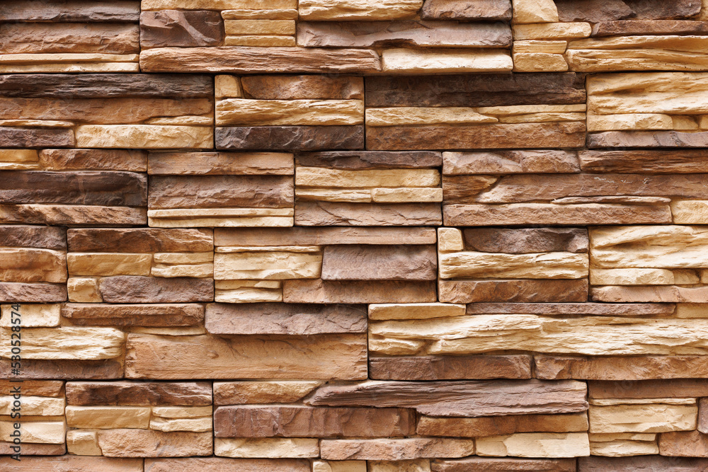 Brick wall cladding with narrow natural stones of various sizes and shapes. Brick wall cladding with narrow natural stones of various sizes and shapes.