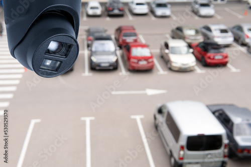 Technician installed IP CCTV camera hi-technology for look security area of work in car parking lot show signage with security cars park in area