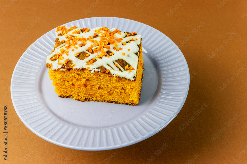 slice of carrot cake with white cream on a brown background slice of carrot cake with white cream on a brown background