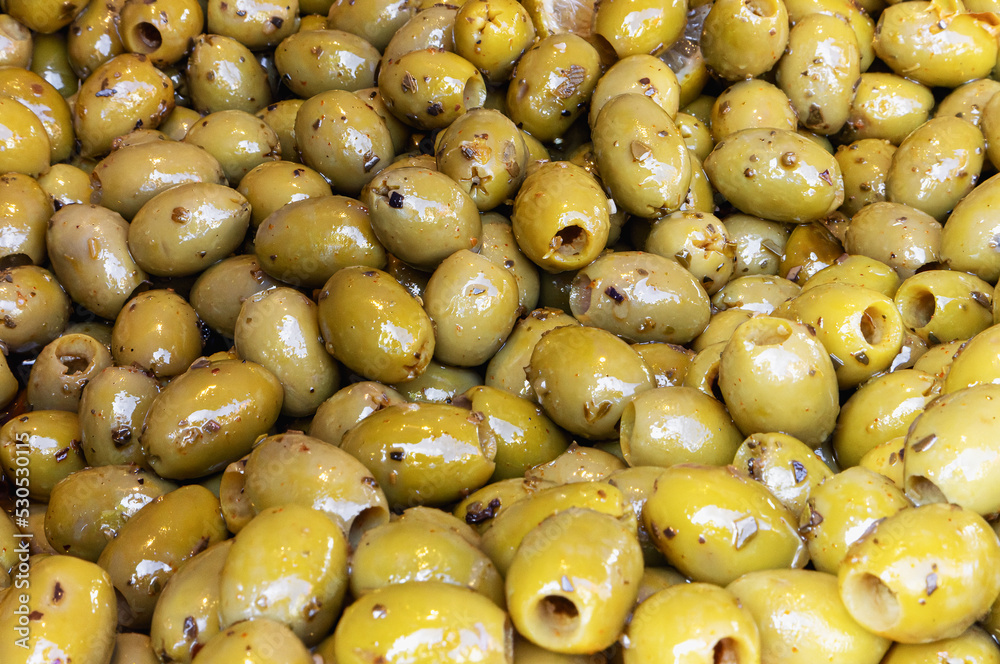 Marinated pitted olives with spices as background Marinated pitted olives with spices as background