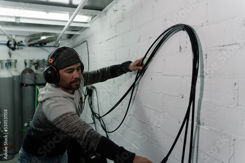 Man checking some cables in a workshop