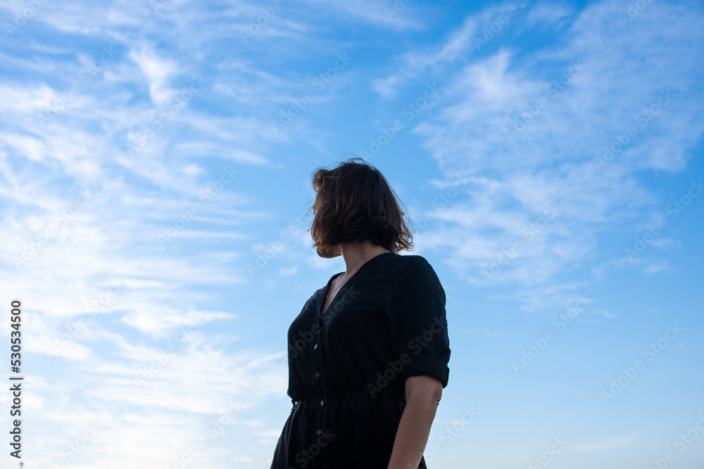 Low angle view of woman standing and looking back Low angle view of woman standing and looking back