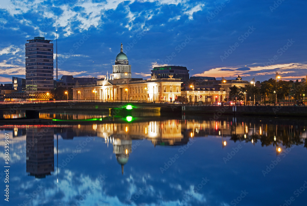 Dome of the Customs house reflected in the River Liffey illuminated at dusk