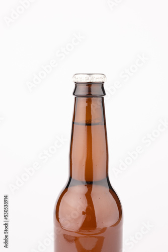 Image of brown glass full lager beer bottle with crown cap, with copy space on white background