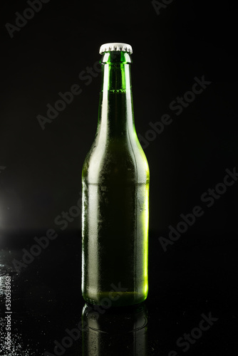 Image of green glass beer bottle with white crown cap, with copy space on black background