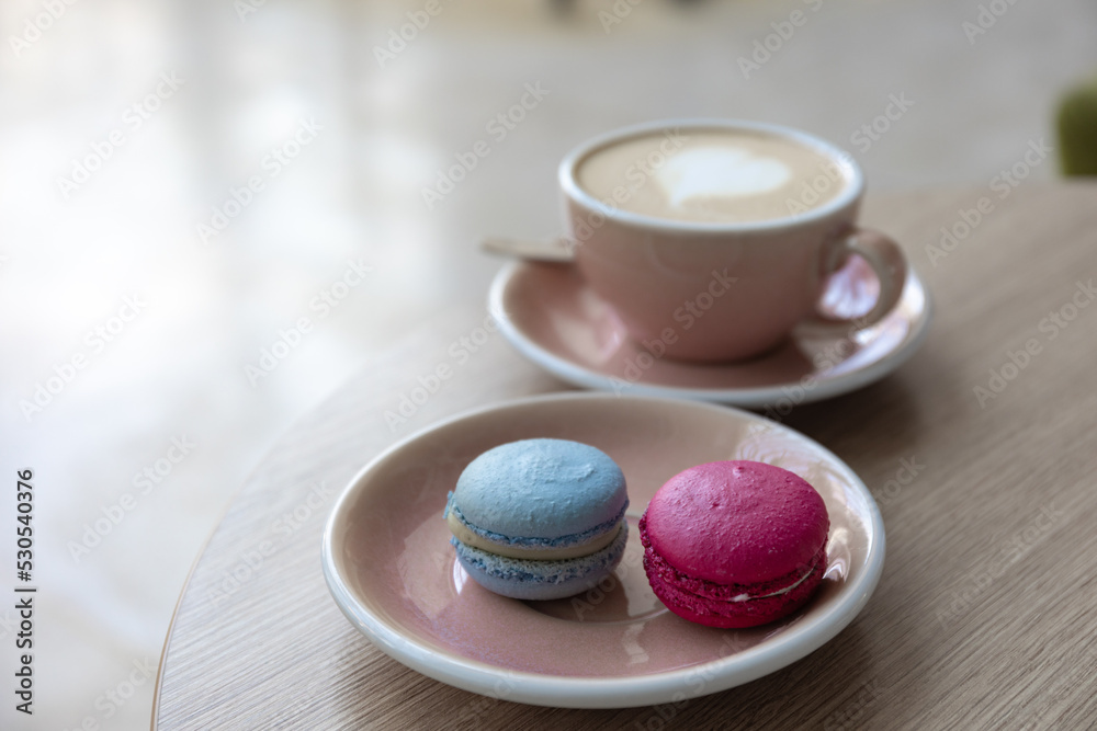 Cup of coffee in a wood table whit blue and purple macaroon Cup of coffee in a wood table whit blue and purple macaroon