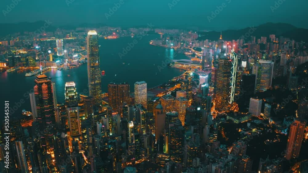 Drone shot of the bay of Hong Kong nearly at night showing the extent of the wealth of the city and the boat traffic.
