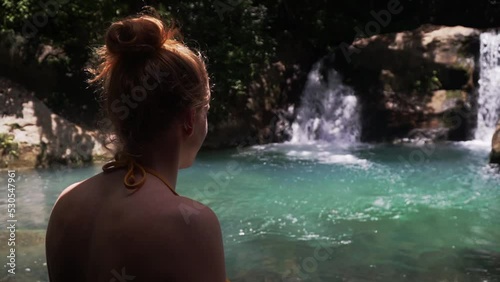 young attractive caucasian woman standing in front of scenic waterfall landscape in tropical rainforest Costa Rica central america travel holiday destination in Las Chorreras, Liberia, photo