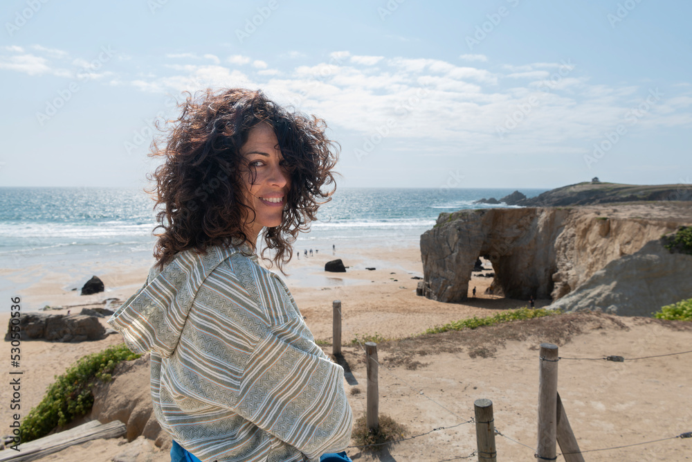 Portrait of a young girl on the spectacular cliff and stone arch of Port Blanc on the famous Côte Sauvage coast, Quiberon, Brittany, France.