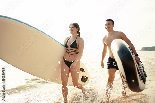 People man and woman go riding water sport sup board. © muse studio