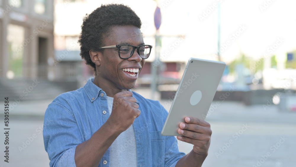 Young African Man Celebrating Online Win on Tablet Outdoor Young African Man Celebrating Online Win on Tablet Outdoor