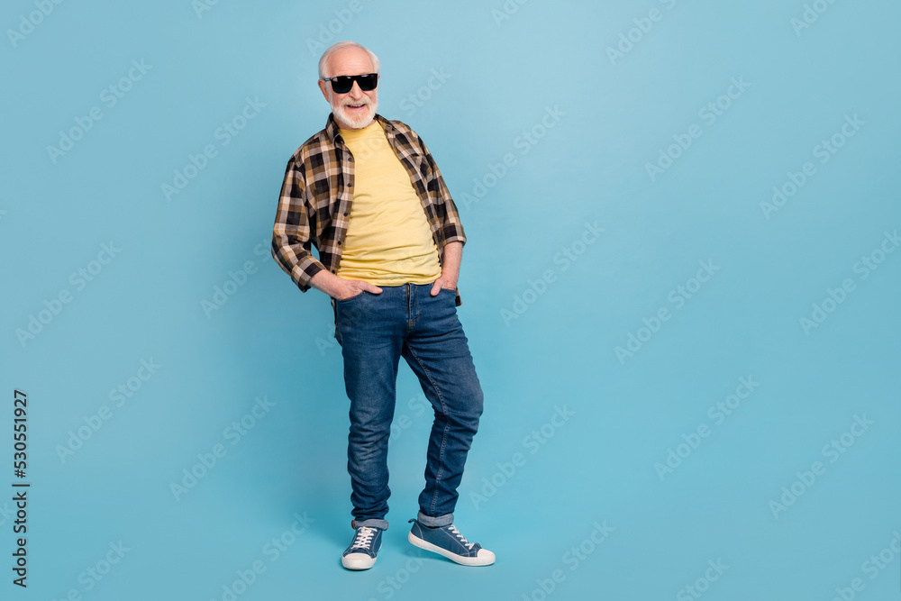 Photo of cute charming man pensioner dressed checkered shirt dark eyewear empty space isolated blue color background Photo of cute charming man pensioner dressed checkered shirt dark eyewear empty space isolated blue color background