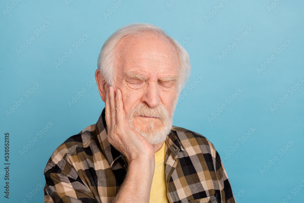 Photo of sad stressed man pensioner dressed checkered arm cheek wisdom ache isolated blue color background