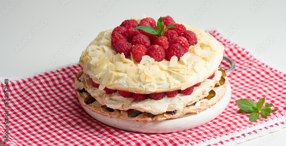 Round meringue pie with fresh raspberries on a white background, Pavlova dessert Round meringue pie with fresh raspberries on a white background, Pavlova dessert