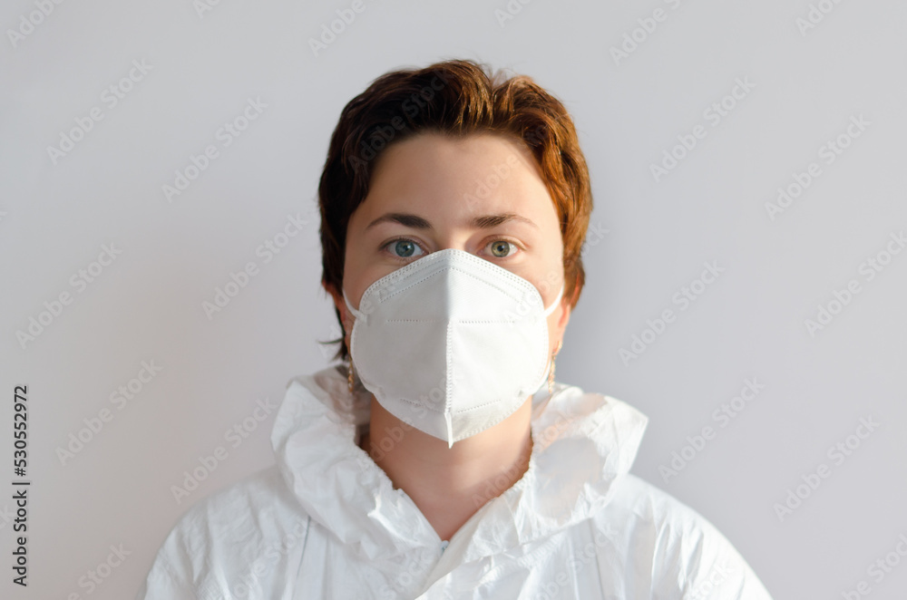 Portrait of professional confident young doctor in a medical mask, white coat. White background. Top view of syringe and vaccine vial glass bottle for vaccination COVID-19. Coronavirus pandemic Portrait of professional confident young doctor in a medical mask, white coat. White background. Top view of syringe and vaccine vial glass bottle for vaccination COVID-19. Coronavirus pandemic