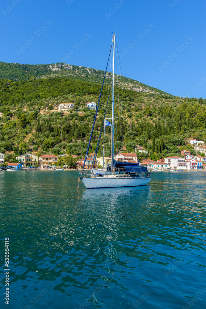 view of a sailboat moored in the picturesque port of Vathy village, the capital of Ithaca island, Ionian, Greece.