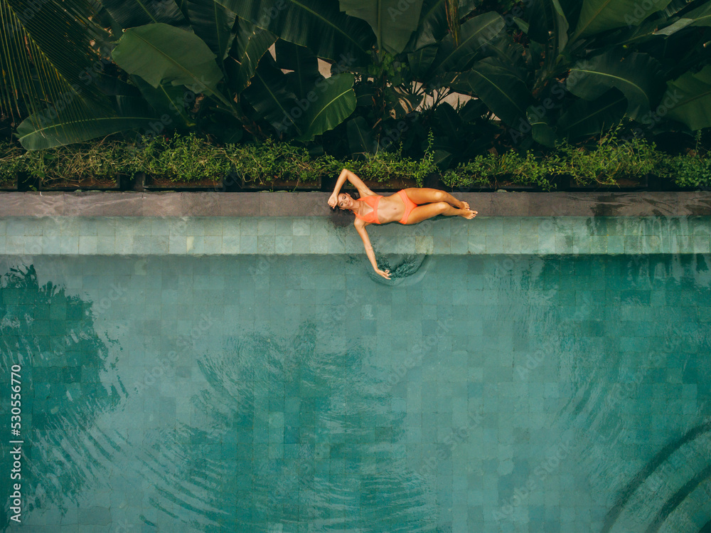 Beautiful woman lying at the poolside - obrazy, fototapety, plakaty 