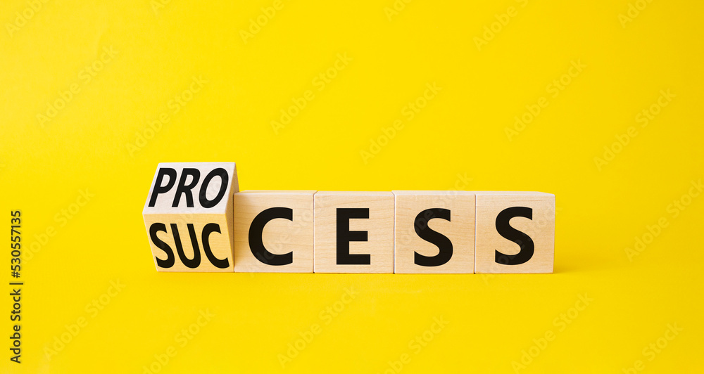 Process and Success symbol. Turned cube with words success and process. Beautiful yellow background. Businessman hand. Business and process and success concept. Copy space Process and Success symbol. Turned cube with words success and process. Beautiful yellow background. Businessman hand. Business and process and success concept. Copy space
