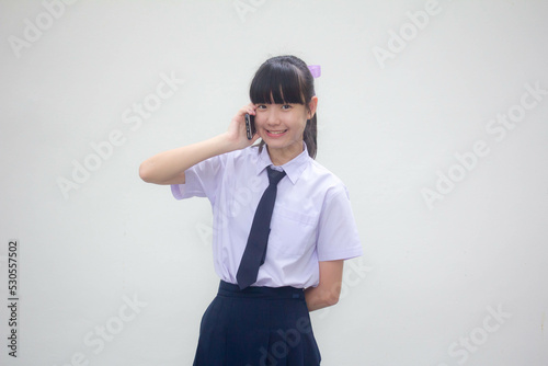 Portrait of thai Junior high school student uniform teen beautiful girl calling smart phone
