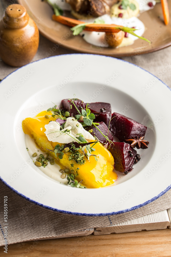 Healthy meal with grilled chicken, beets and cheese on white plate on the table Healthy meal with grilled chicken, beets and cheese on white plate on the table