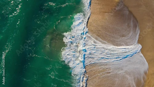 Cenital view of the sea and the waves on a spring day, blue, green and orange combinatios photo