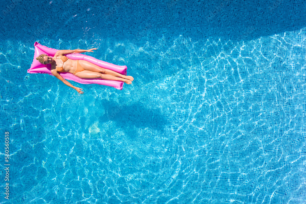 Overhead Drone Shot Of Woman On Summer Holiday Floating On Inflatable Airbed In Swimming Pool