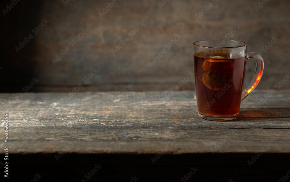 A cup of tea with a sachet on a wooden background. A cup of tea with a sachet on a wooden background.