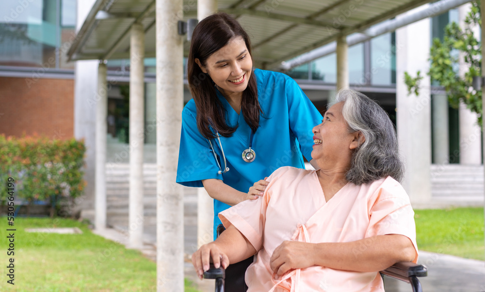 Obraz premium Asian careful caregiver or nurse taking care of the patient in a wheelchair. Concept of happy retirement with care from a caregiver and Savings and senior health insurance, a Happy family