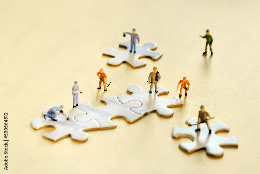 Team of tiny worker miniature figures on linked jigsaw puzzle pieces on  golden yellow paper. Closeup on white jigsaw puzzle elements. Creative Team  work in construction, development, logistics. Photos | Adobe Stock
