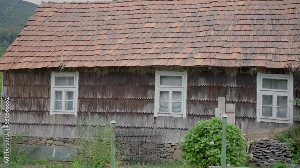 Old wooden house in the Carpathians, in the mountains, tiled roof