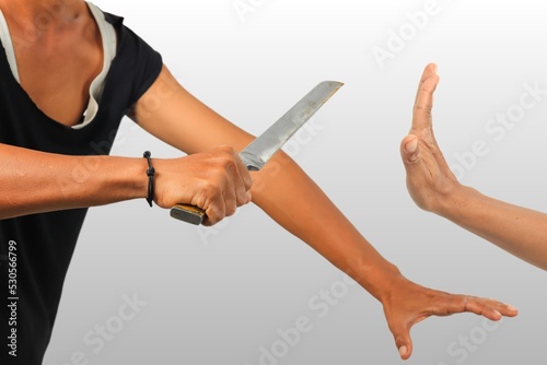 Hand holding knife and rejecting gesture, bad situation illustrative.