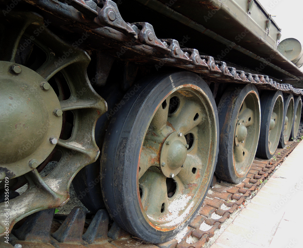 Wheels and suspension of rare tracked war machine with dirt and rust on a tracks