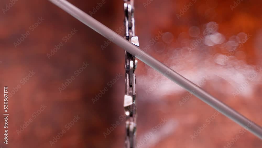 The process of sharpening chainsaw chain teeth with a round file close-up. Maintenance and preparation of the tool for work. Self repair saw on blurred background. Top view. The process of sharpening chainsaw chain teeth with a round file close-up. Maintenance and preparation of the tool for work. Self repair saw on blurred background. Top view.