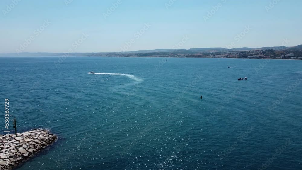 Boat speeding in majestic blue water near Spanish coastline, aerial view Boat speeding in majestic blue water near Spanish coastline, aerial view