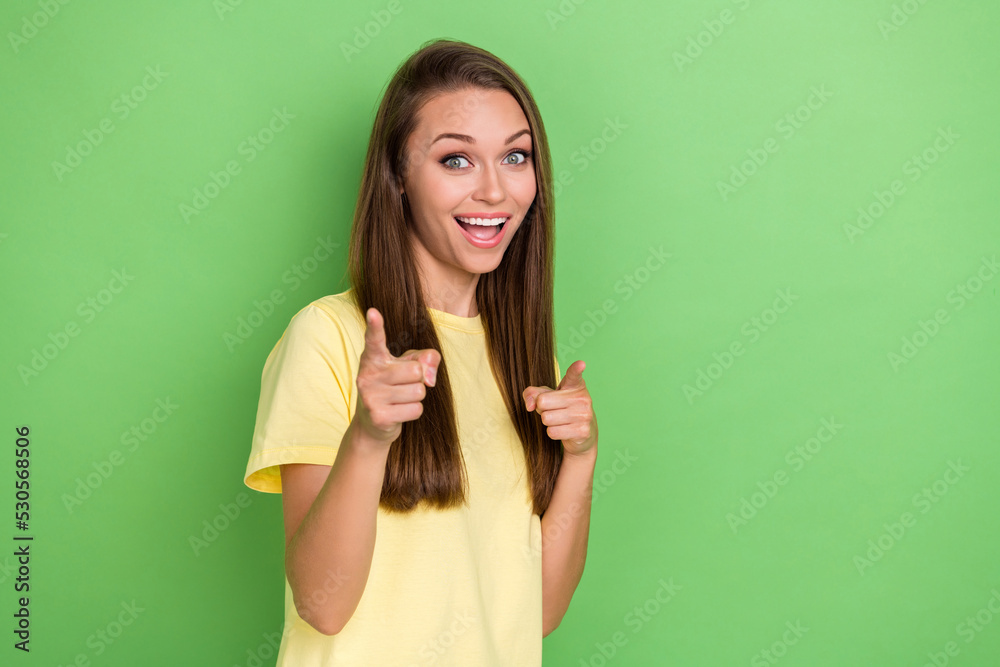 Portrait of cute nice lovely girl with straight hairstyle wear yellow t-shirt indicating at you on camera on green color background