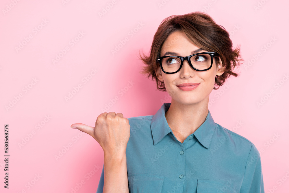 Portrait of cheerful girl with bob hairdo dressed blue blouse spectacles directing look empty space isolated on pink color background Portrait of cheerful girl with bob hairdo dressed blue blouse spectacles directing look empty space isolated on pink color background