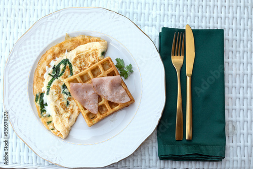 Morning breakfast. Freshly homemade baked spinach waffles and omelette with bacon