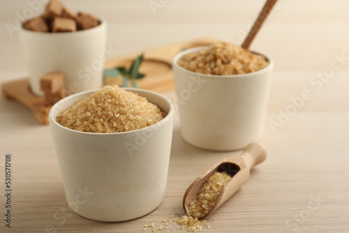 Bowls with different types of brown sugar on wooden table