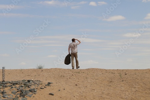 Man walking in the desert gazing in the distance