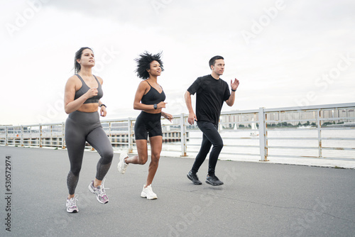 A group of people are runners in sportswear. Running friends workout fitness in the city.