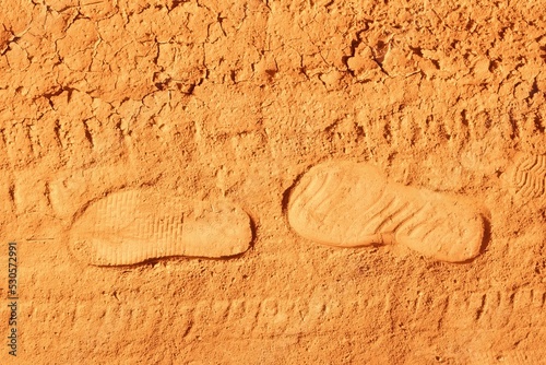 Footprints from shoes on dry, dusty ground