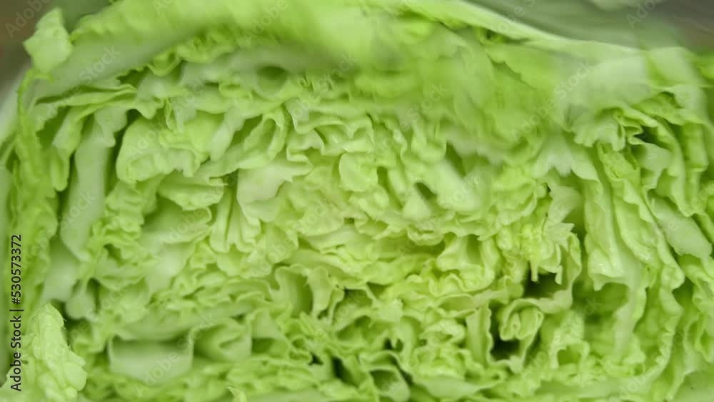 Macro shot of cutting fresh chinese cabbage. Cooking food. Vegetables, greens. Coleslaw. Close-up Macro shot of cutting fresh chinese cabbage. Cooking food. Vegetables, greens. Coleslaw. Close-up