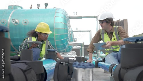 Team of engineers is inspecting the air conditioning cooling system of a large building or industrial plant.